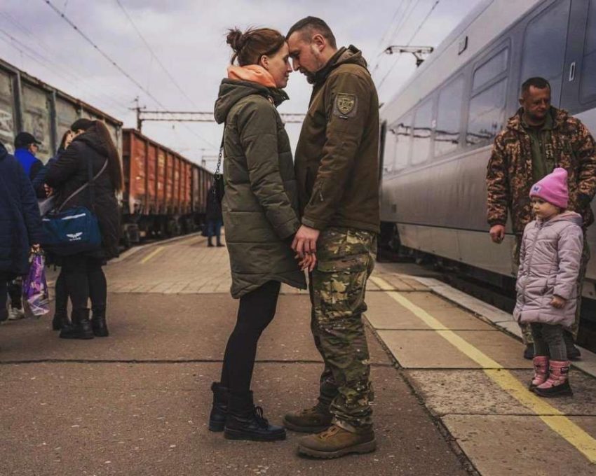 Військовий та жінка обіймаються на платформі, переживаючи горе війни