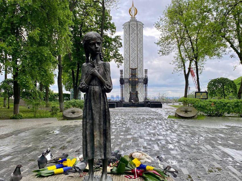 Меморіал Голодомору-геноциду зі статуєю дівчинки та квітами